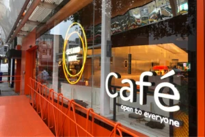 Cafe lettering and circular illuminated sign in a window