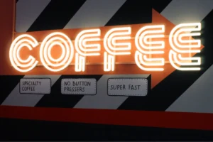 Illuminated COFFEE lettering above a counter