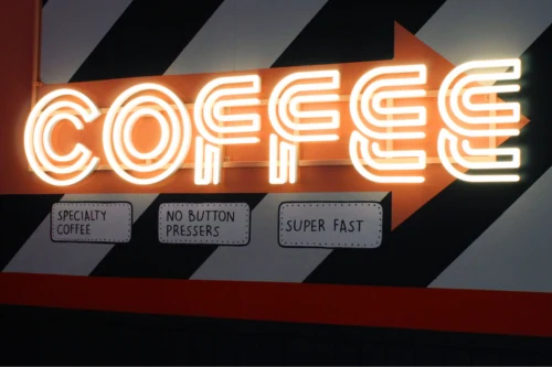 Illuminated COFFEE lettering above a counter