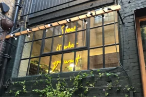 Illuminated lettering viewed through a restaurant window