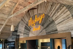 Mowgli illuminated sign on a timber interior wall