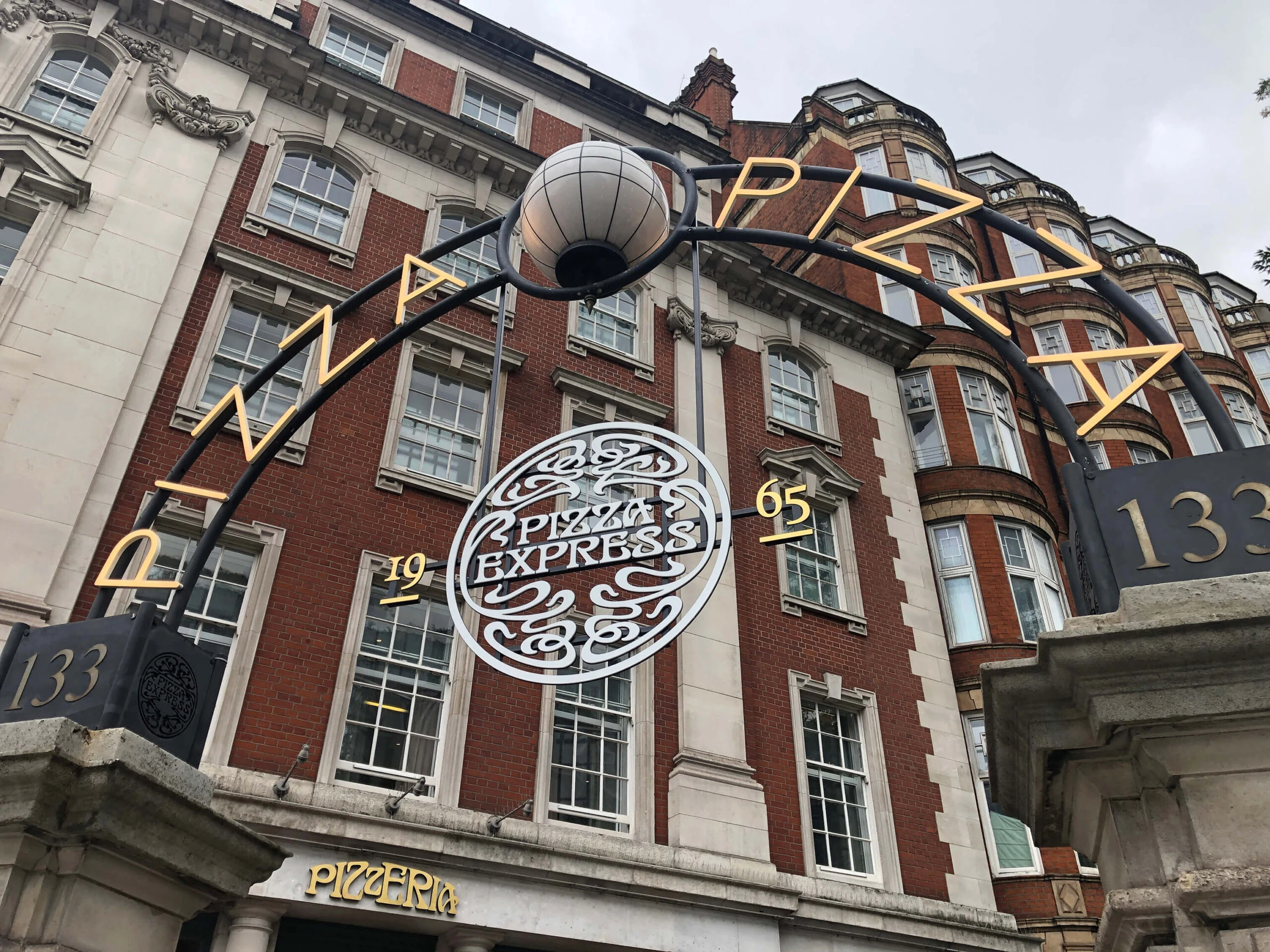 PizzaExpress projecting sign and metalwork outside a brick building